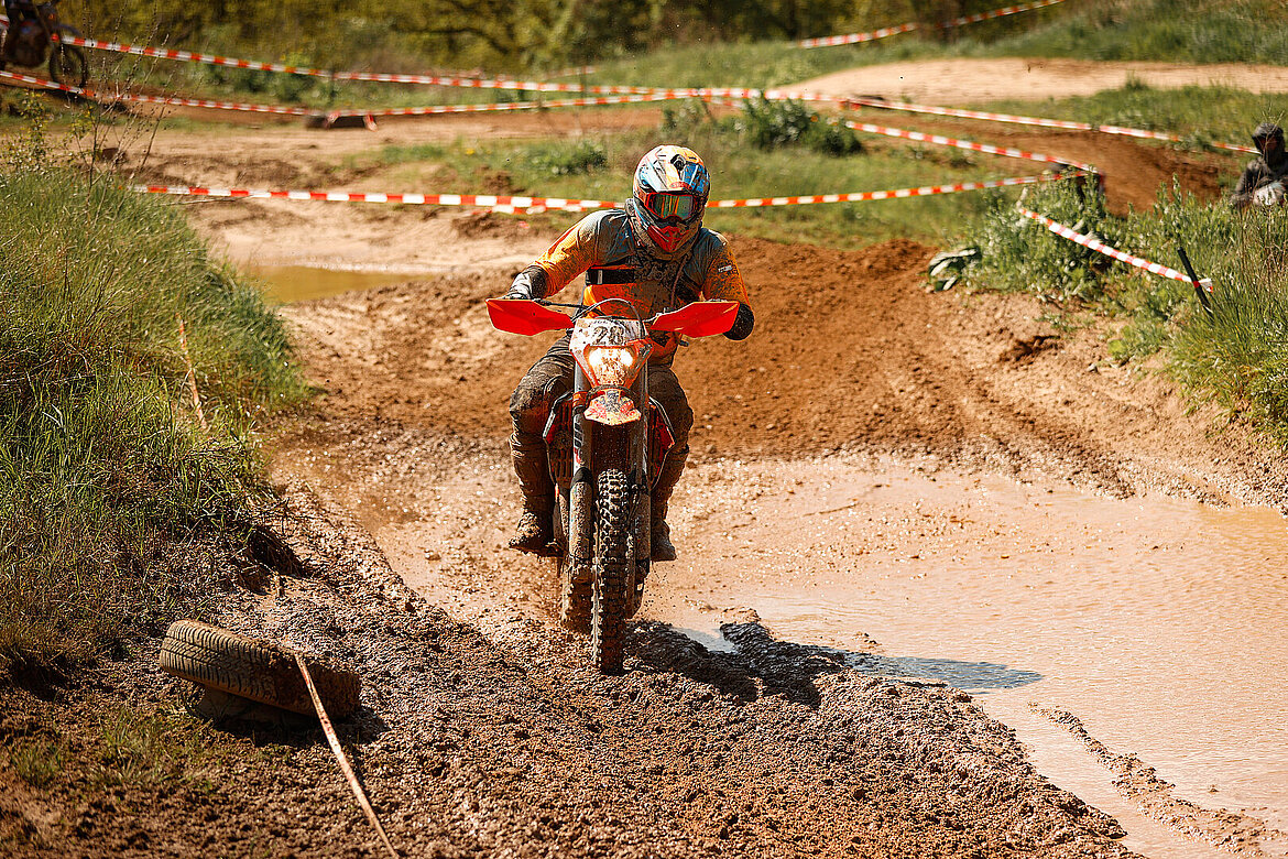 Endurofahrer auf einer abgesperrten Strecke mit Schlamm und Wasser